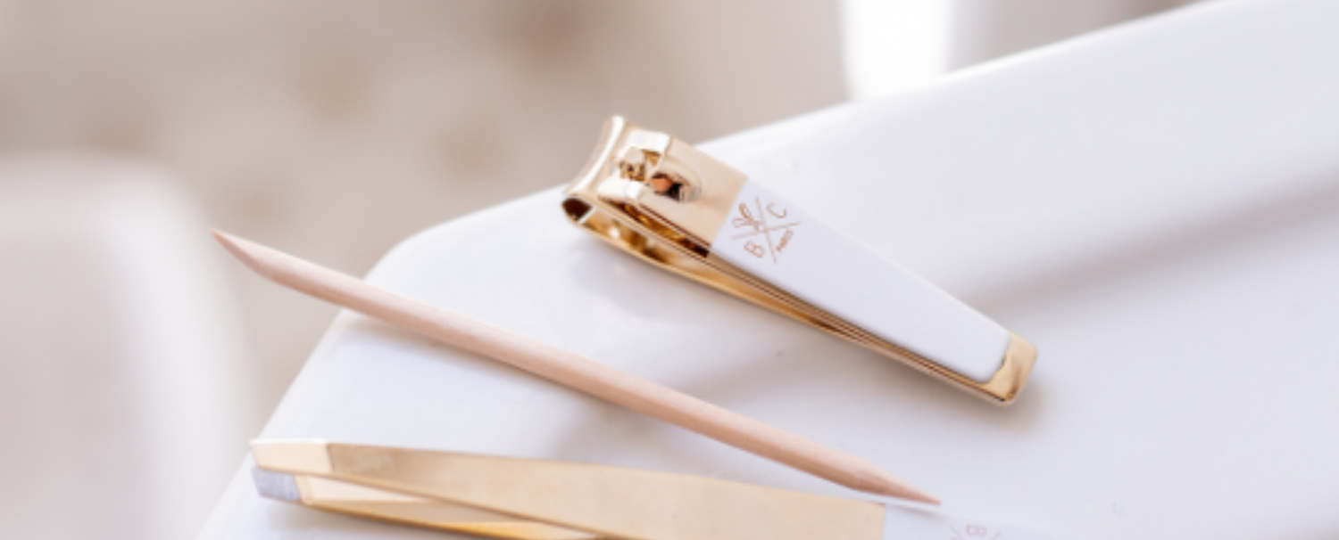 Gros plan sur les accessoires du kit manucure de la marque Bachca : coupe ongle, repousse cuticules, pince à épiler.