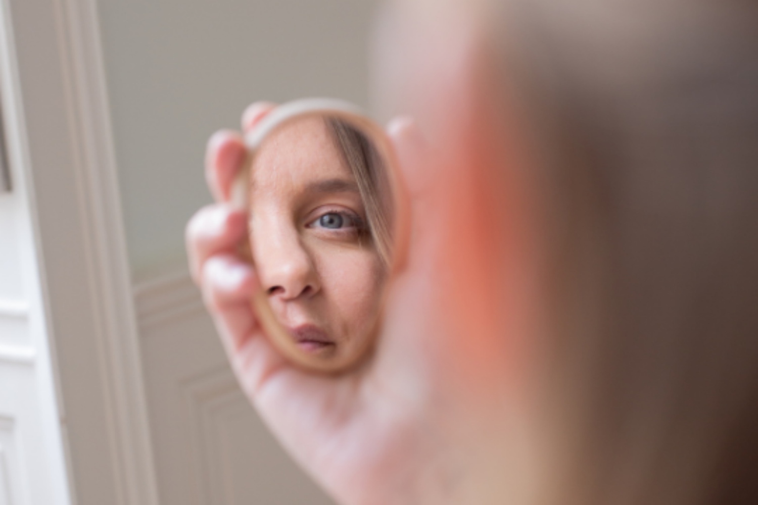Femme aux yeux bleus se regardant dans un miroir de la marque Bachca.
