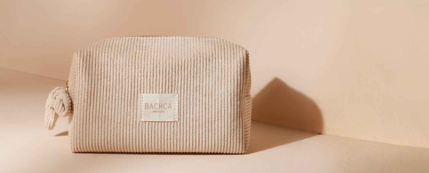 Photo studio sur fond rose pâle de la trousse de maquillage en velours côtelé beige de la marque Bachca.