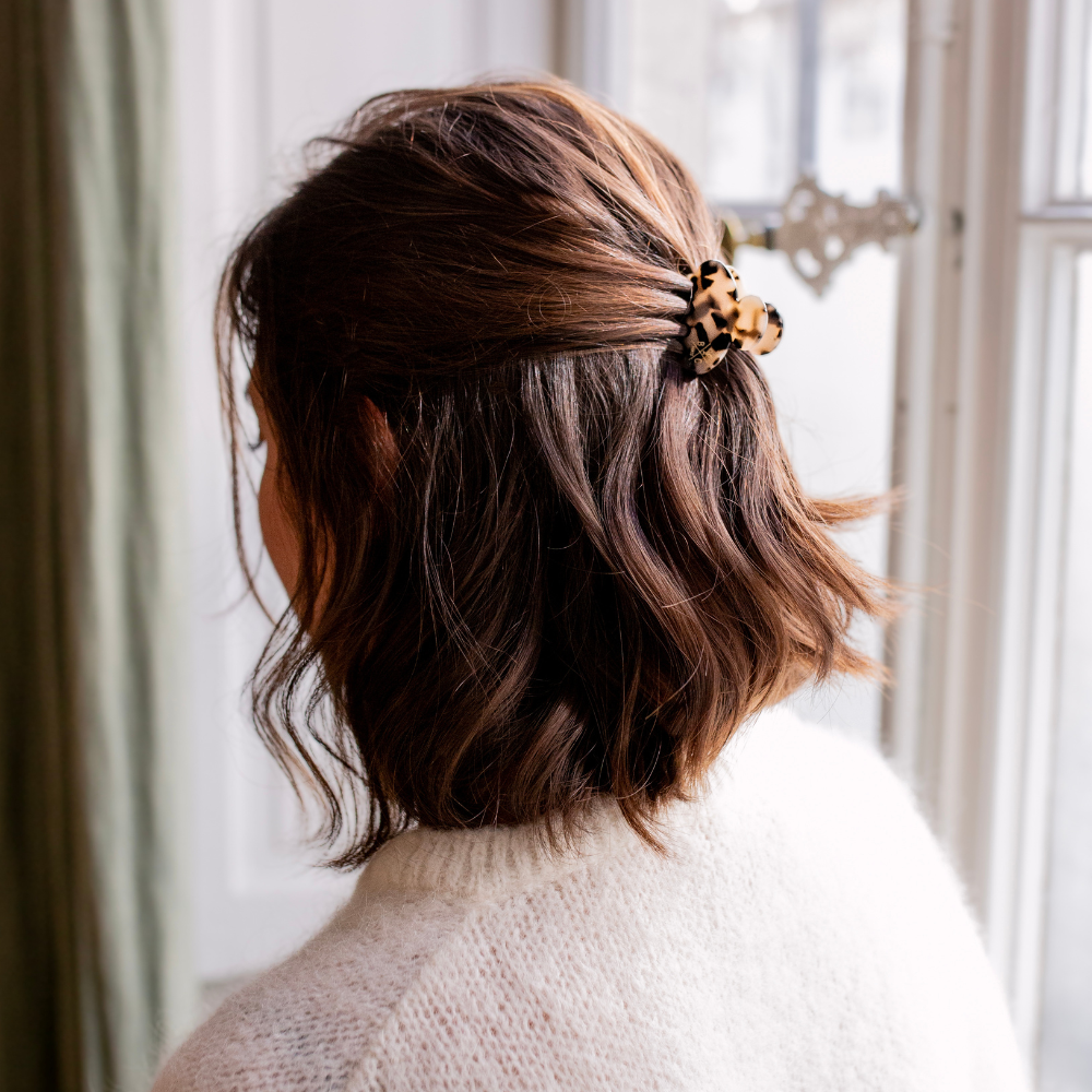Petite pince à cheveux écaille Bachca portée en demi-queue sur cheveux bruns courts.