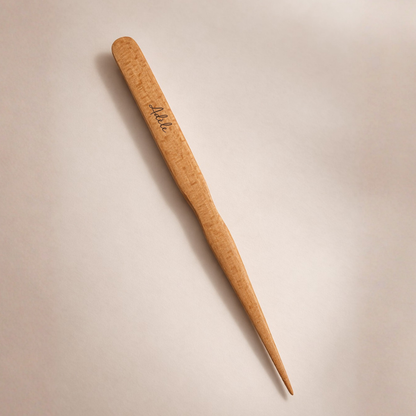Brosse à cheveux plaquage de la marque Bachca sur un fond studio beige, vue de dos avec une gravure sur bois " Adèle".