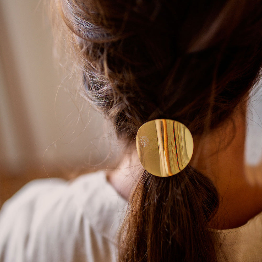 Queue de cheval attachée avec l’élastique plaque doré Bachca, un accessoire cheveux élégant qui allie praticité et raffinement pour sublimer toutes les coiffures.